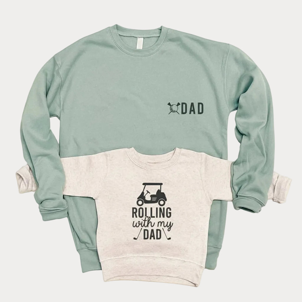 Matching sweatshirts for Dad and Kid: the sage adult says "Dad," and the natural-colored long-sleeved sweatshirt for kids says "Rolling with my DAD."