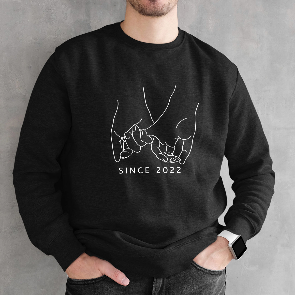 Black sweatshirt with white graphic Holding Pinkies and 'SINCE 2022' text worn by a person against a gray background