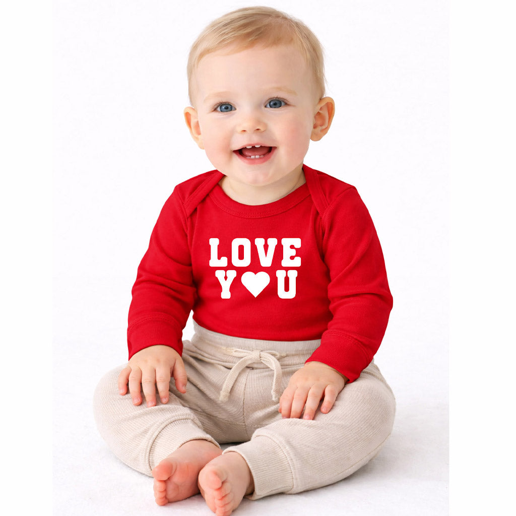 Baby wearing red “Love You” long-sleeve one-piece on white background