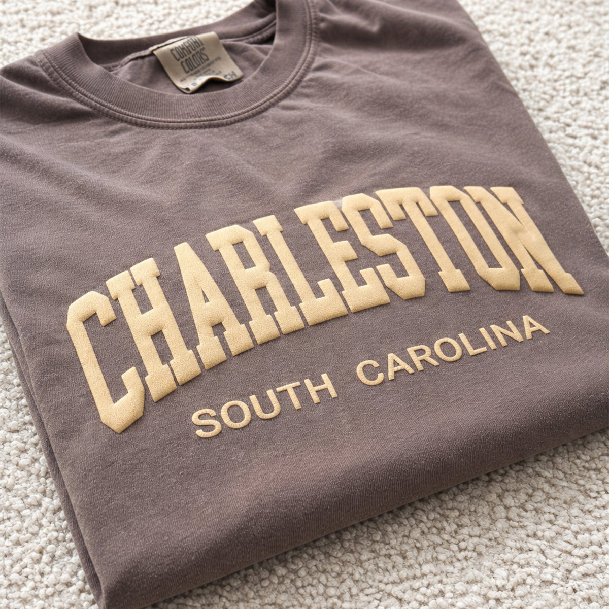 Close up of Charleston South Carolina puff print design on espresso Comfort Colors® t-shirt