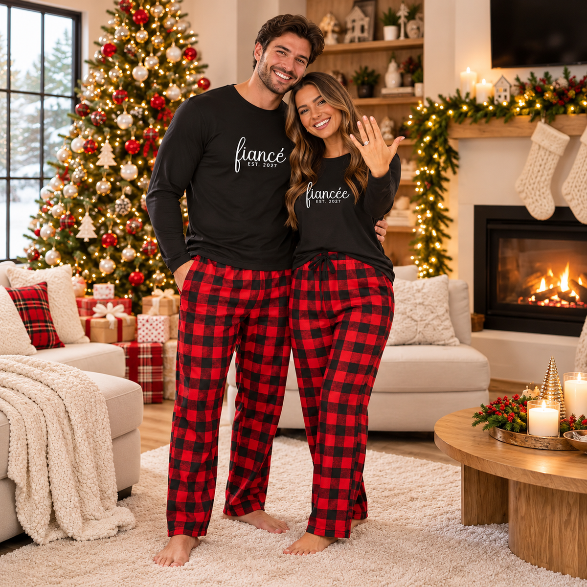 Engaged couple wearing personalized Fiancé and Fiancée long-sleeve shirts with matching flannel pajama pants in a cozy Christmas living room.