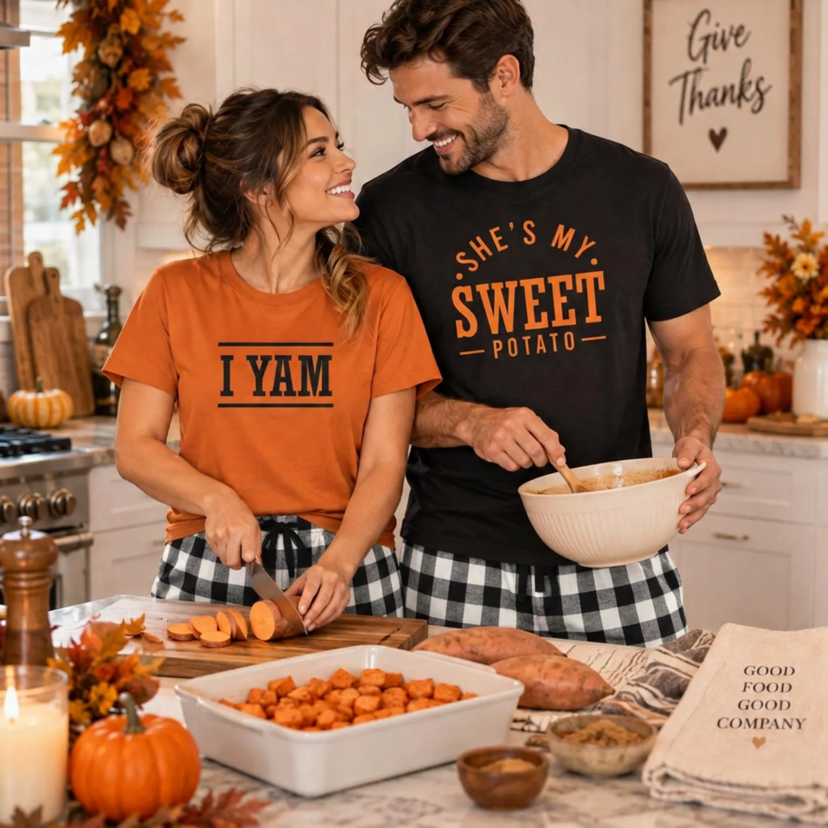 A couple preparing Thanksgiving dinner together, wearing a black She's My Sweet Potato T-shirt and an autumn I Yam T-shirt with white-and-black plaid flannel pajama pants.