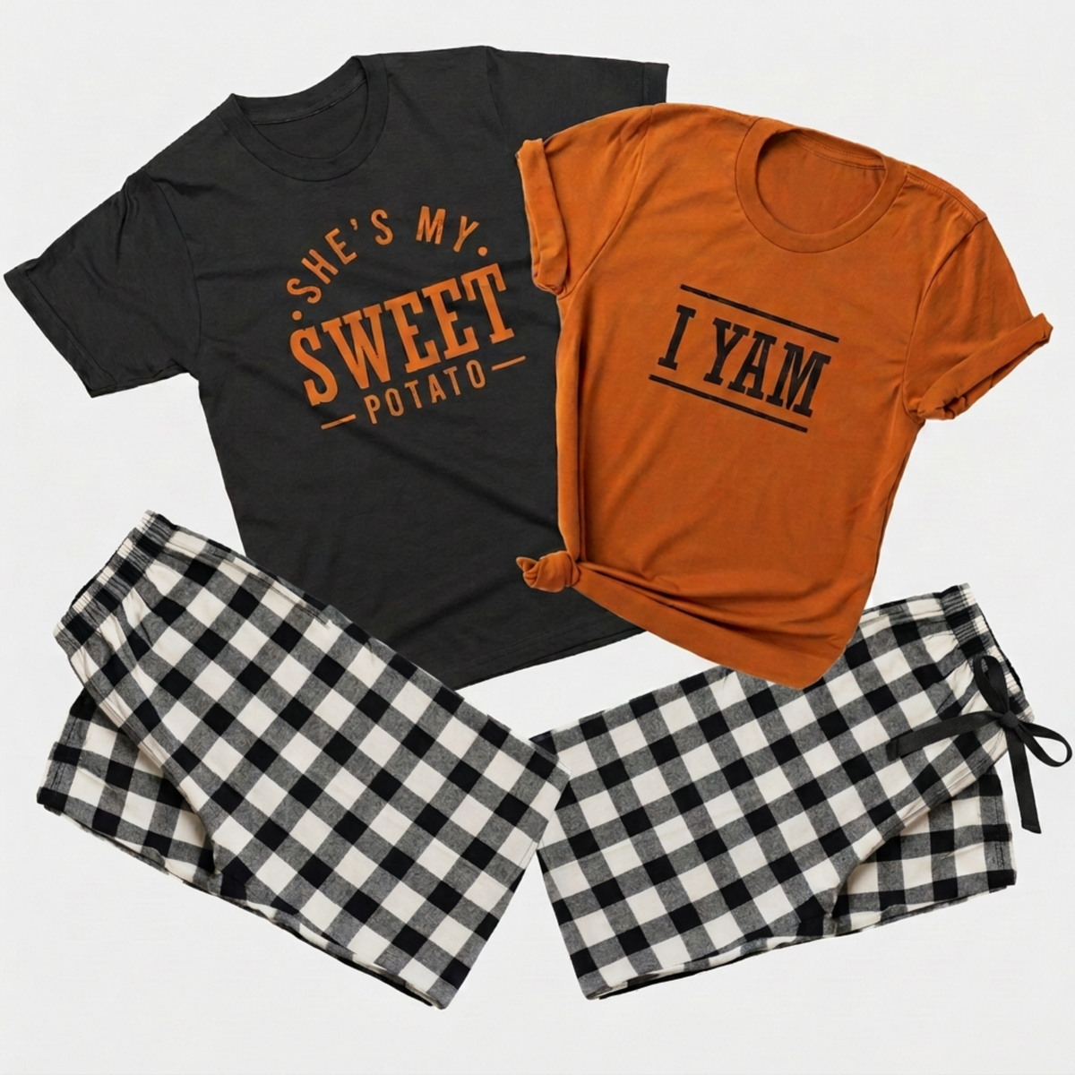Flat lay of matching Thanksgiving pajamas featuring a black She's My Sweet Potato T-shirt, an autumn I Yam T-shirt, and white-and-black plaid flannel pajama pants 