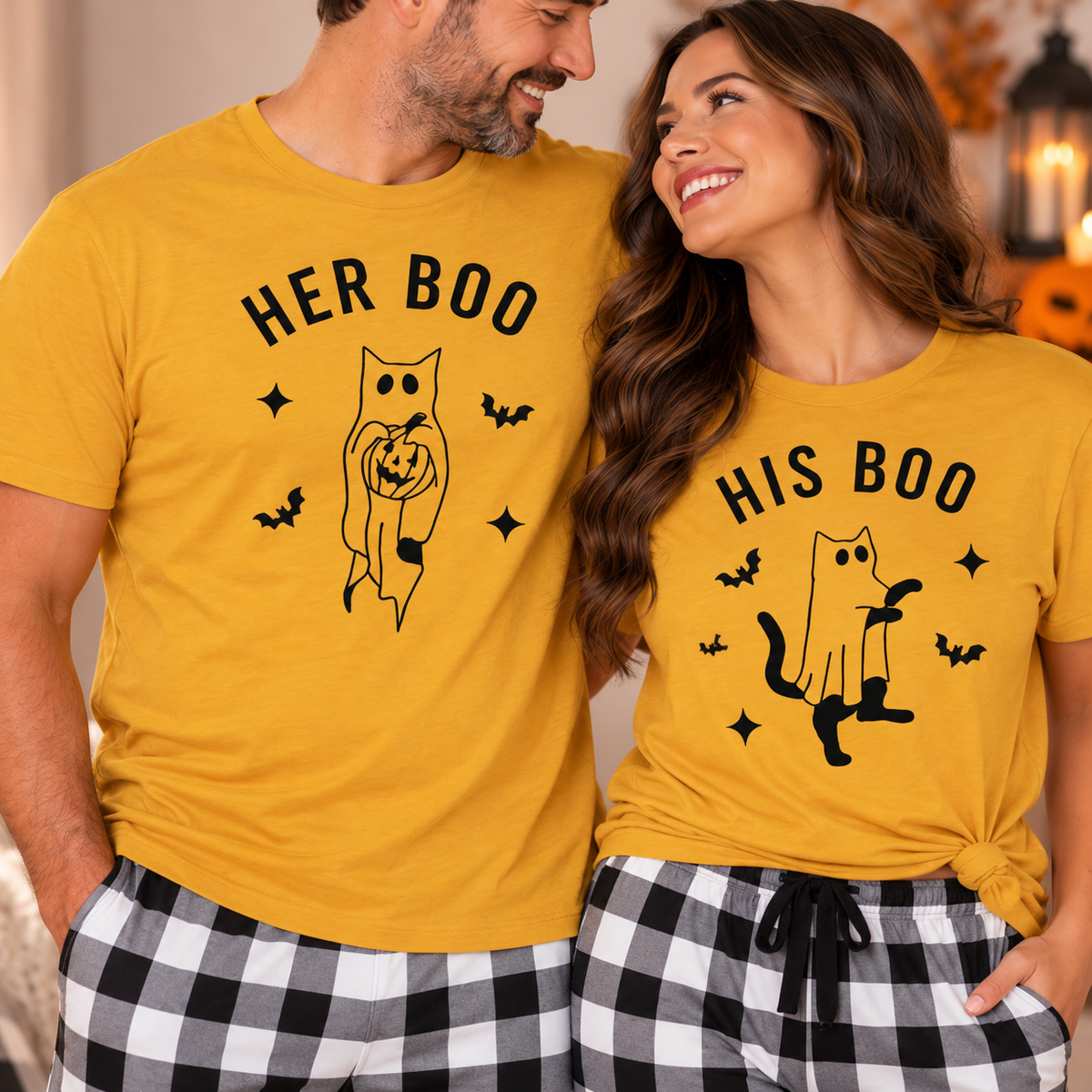 Couple wearing matching mustard Her Boo and His Boo Halloween pajama tops with cat ghost designs and black-and-white checkered flannel pants in a cozy indoor setting