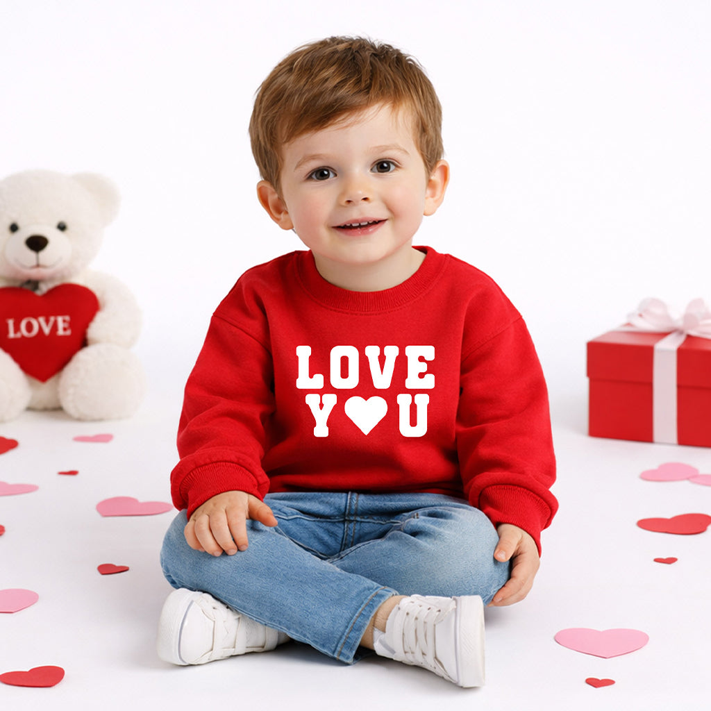 Toddler boy in red “Love You” sweatshirt and youth wearing natural “Love You More” sweatshirt outdoors
