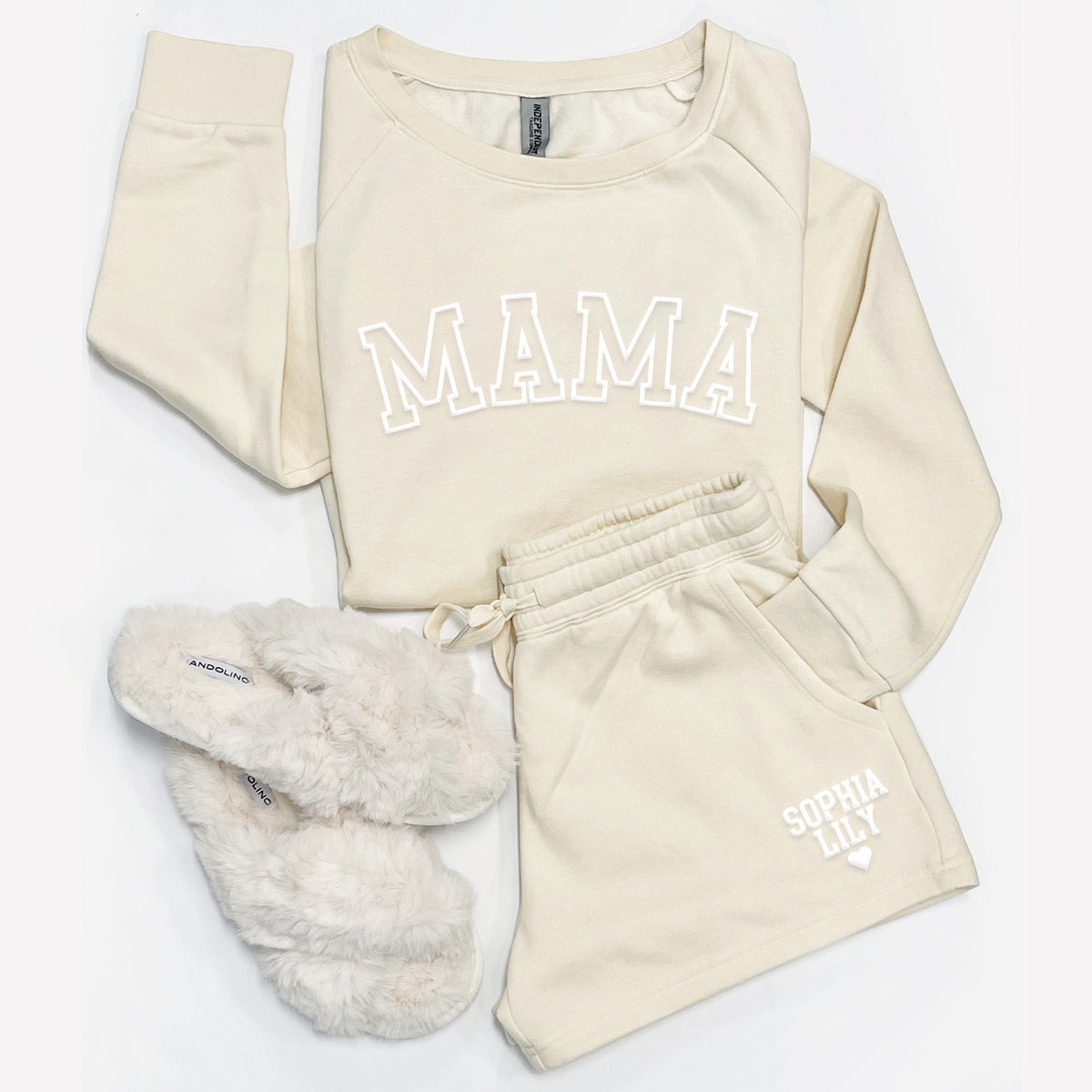Flat lay of bone Mama sweatshirt and personalized sweatshorts with custom name print and cozy slippers.
