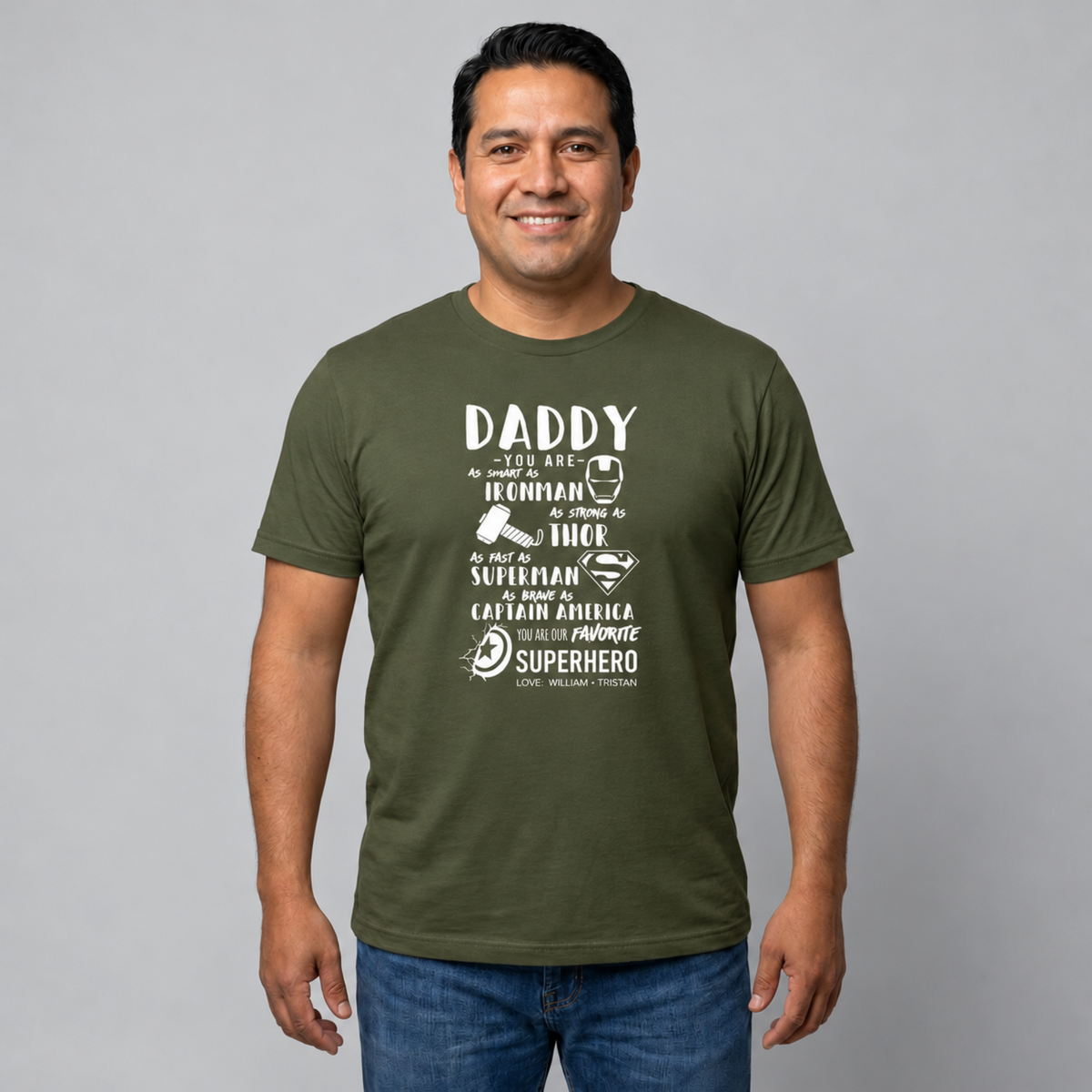 Man wearing a military green personalized Dad T-shirt featuring a superhero design with Iron Man, Thor, Superman, and Captain America graphics and children's names.