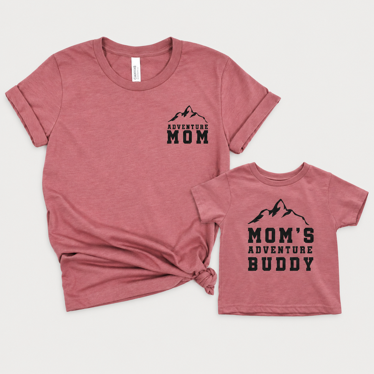 Mauve matching mom and child T-shirts with black mountain graphics and “Adventure Mom” and “Mom’s Adventure Buddy” lettering.
