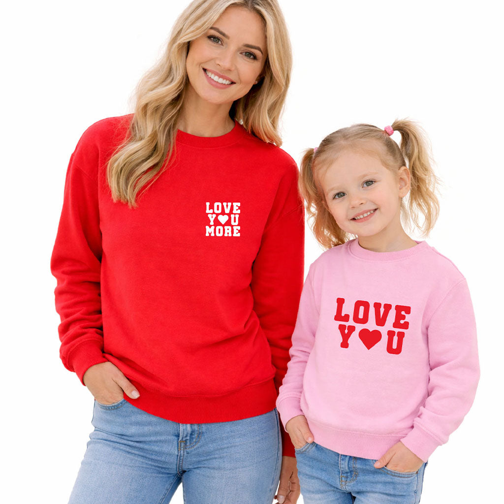 Mother and daughter wearing matching “Love You More” and “Love You” sweatshirts on white background