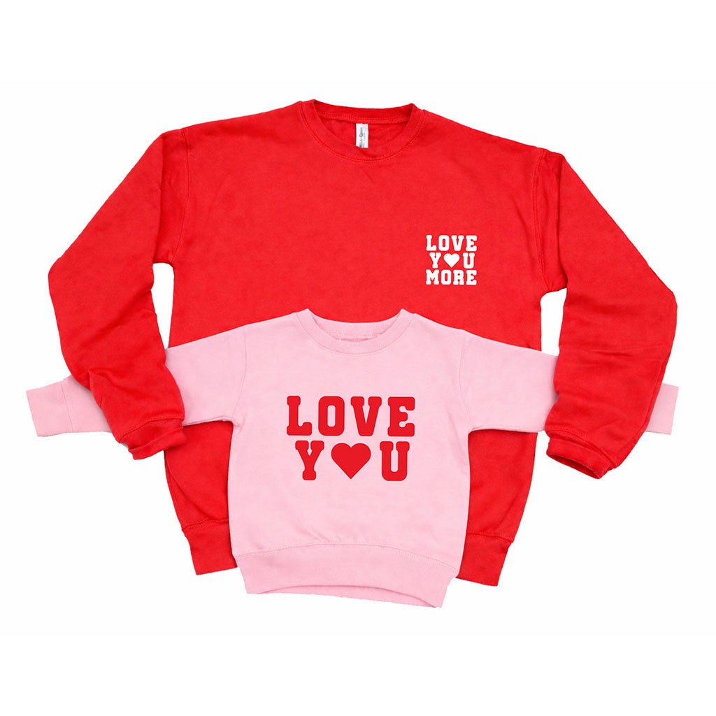 Kids pink “Love You” sweatshirt and mom red “Love You More” sweatshirt matching set on white background