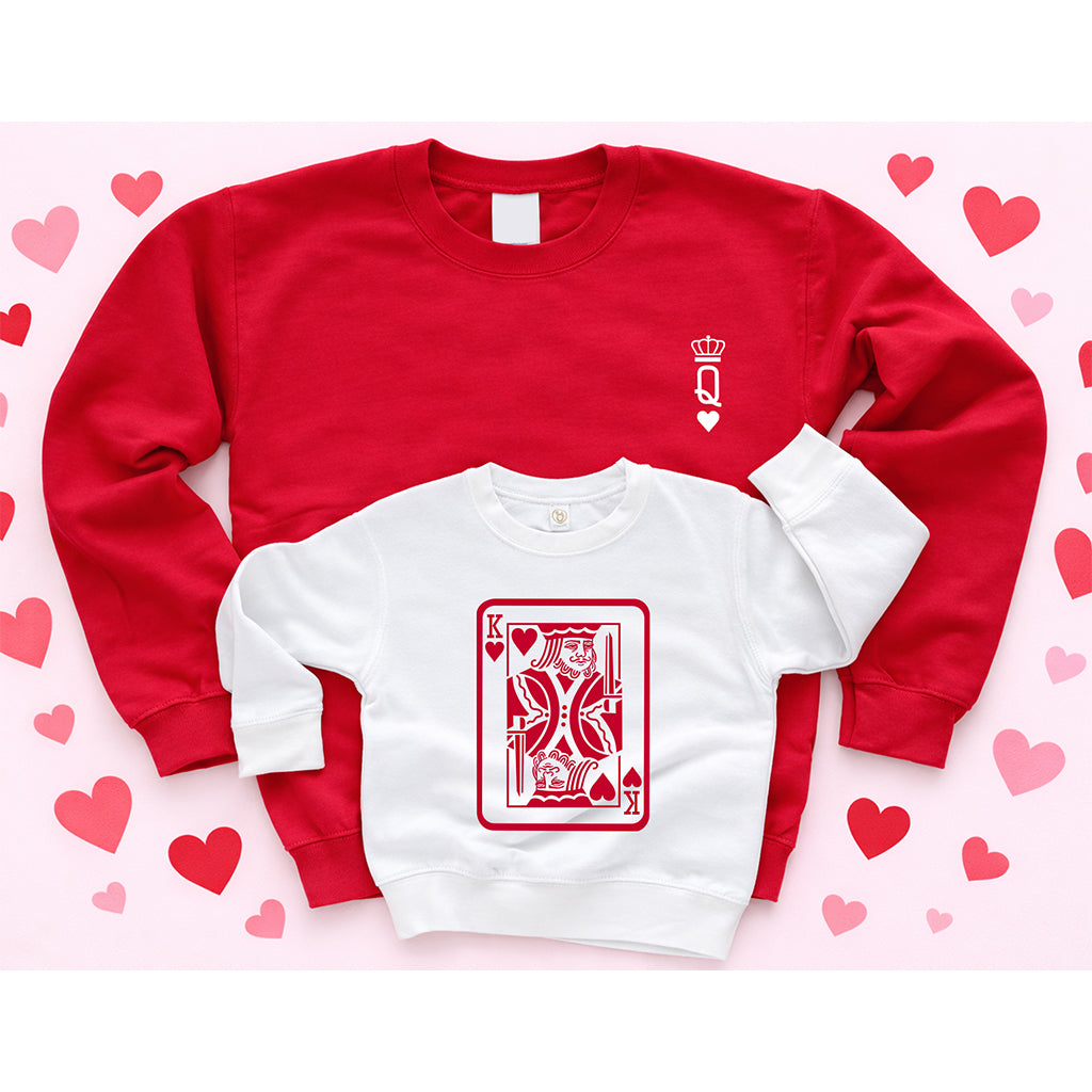 Mom and son matching Valentine’s Day sweatshirts featuring a red adult sweatshirt and white kids sweatshirt on a light pink heart background