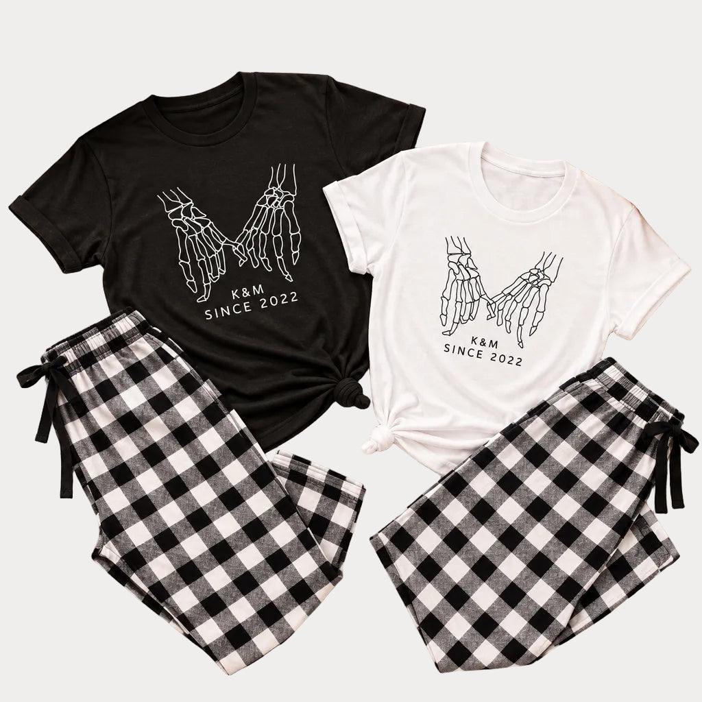 Personalized Halloween couple pajama set with skeleton pinky promise hands design and black and white plaid pants