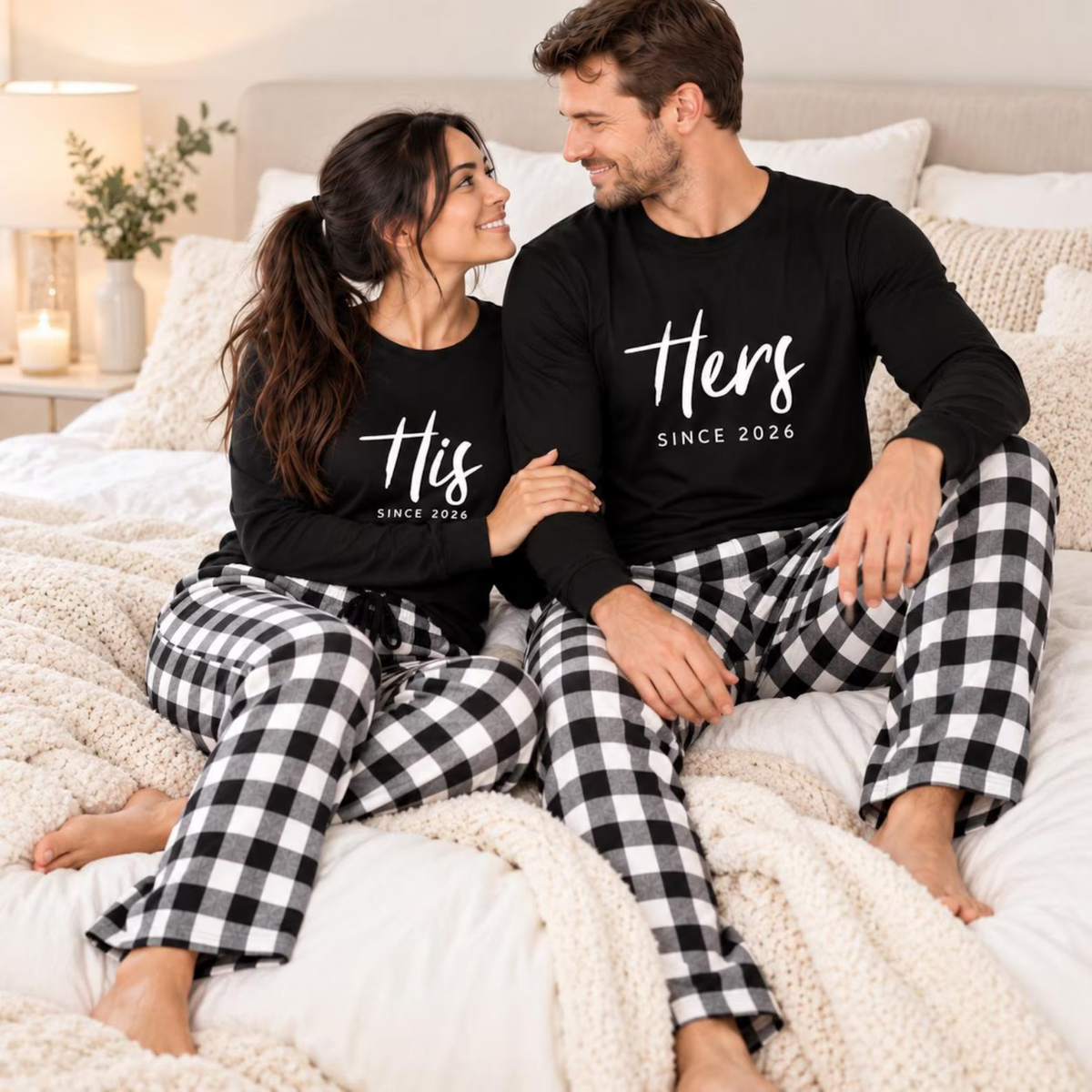 Couple wearing personalized His and Hers matching pajamas with long-sleeve shirts featuring a custom anniversary year and coordinating buffalo plaid flannel pajama pants, relaxing together on a cozy bed.