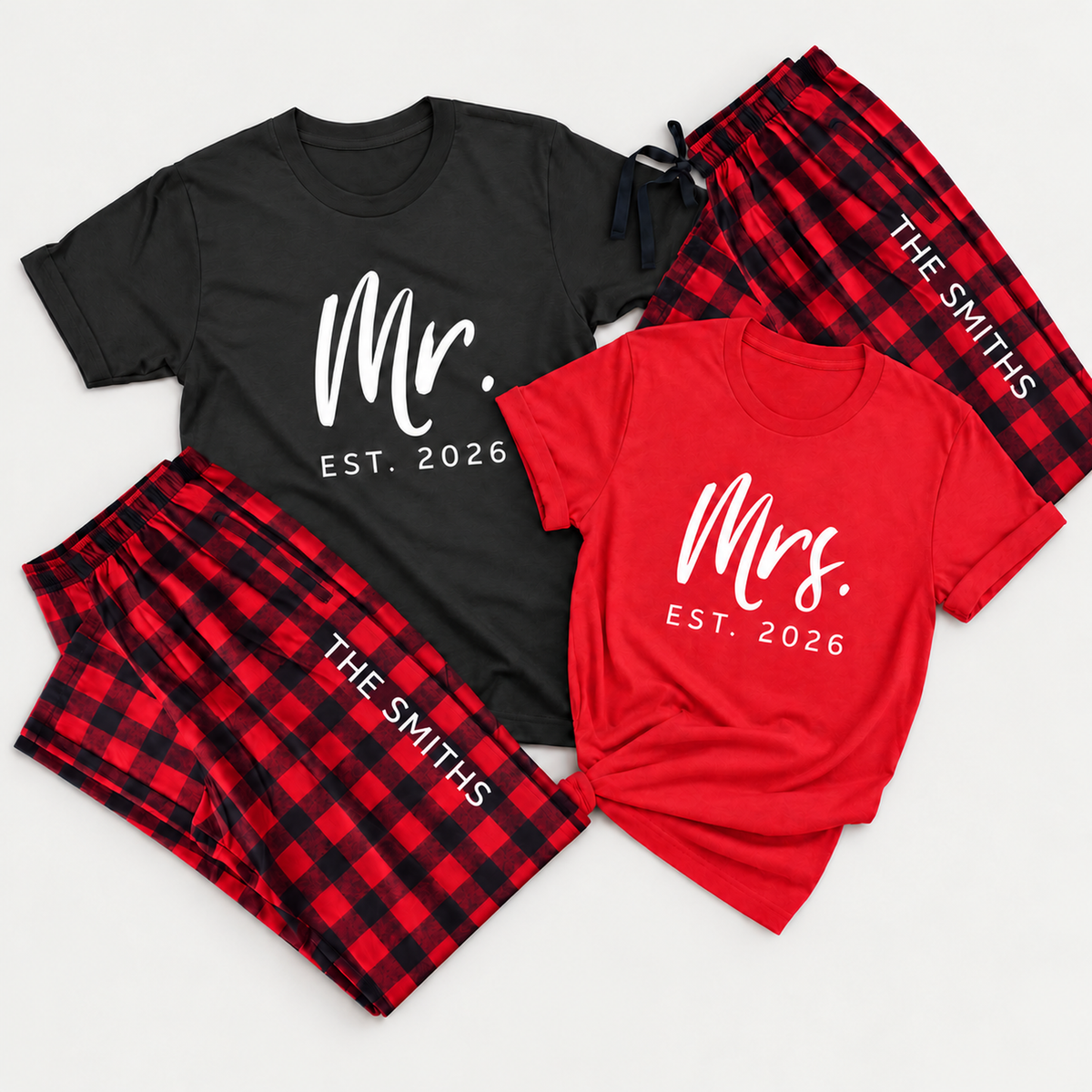 Personalized Mr. and Mrs. matching pajamas featuring 2026 T-shirt designs and red-and-black buffalo plaid pajama pants with a custom last name printed diagonally along each leg.