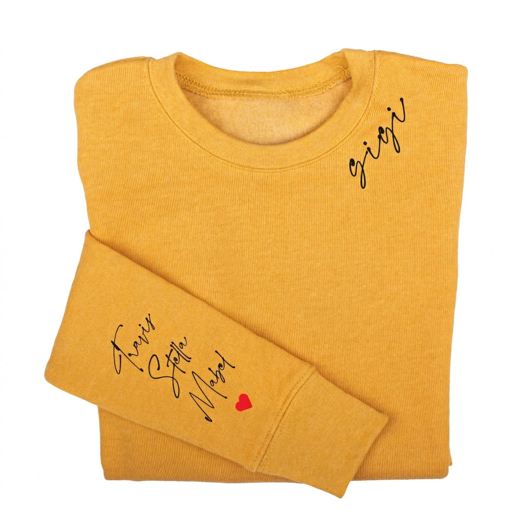 Mustard personalized Grandma sweatshirt featuring custom script lettering on the chest and grandkids' names with a red heart on the sleeve.