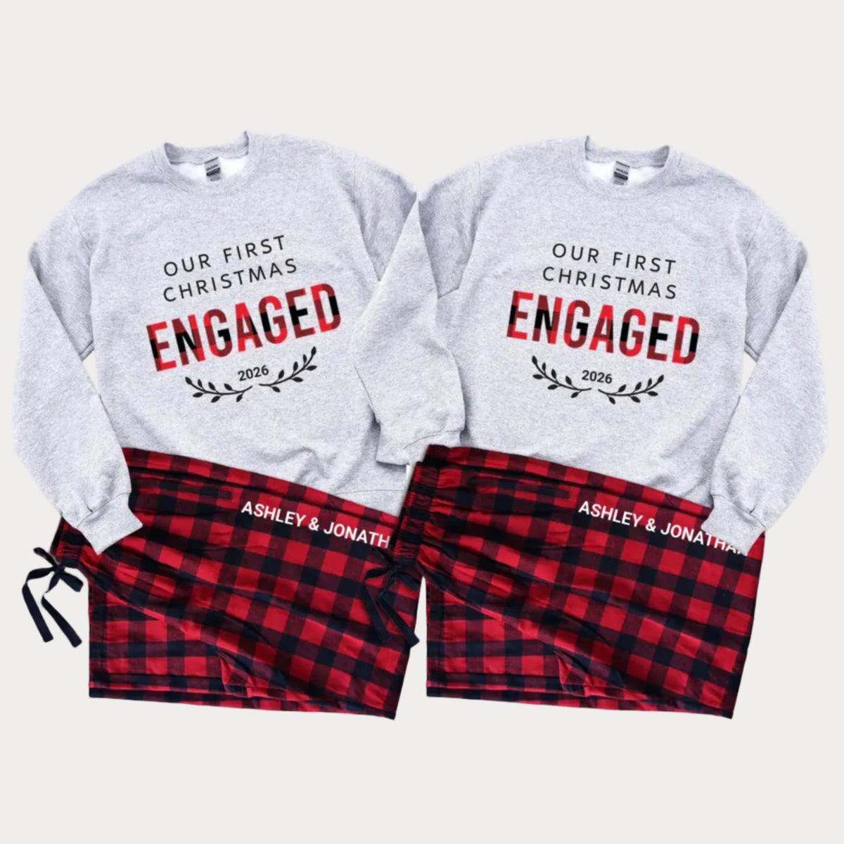 Matching Our First Christmas Engaged 2026 couple sweatshirts paired with personalized flannel pajama pants featuring custom names, displayed as a coordinated Christmas engagement sleepwear set.