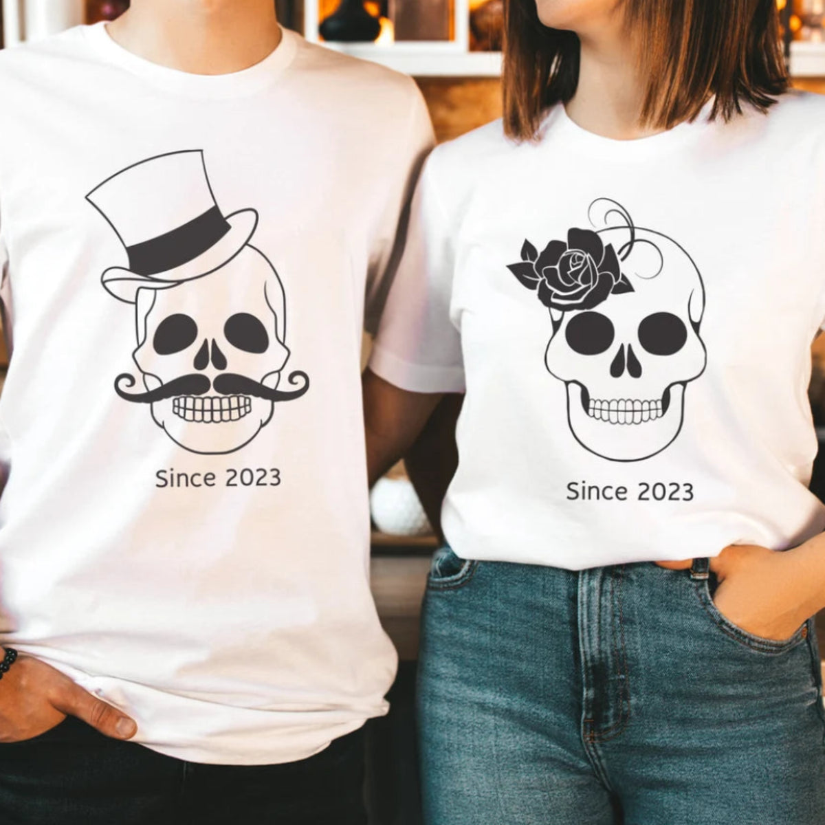 Couple wearing matching white skull Halloween shirts with coordinated His and Hers skeleton designs and Since 2023 text