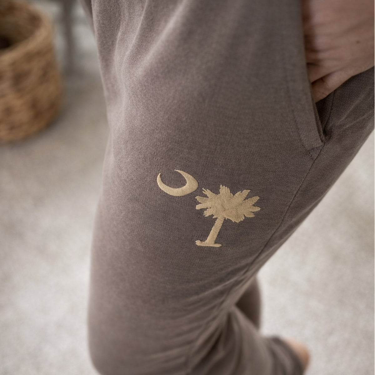 Model wearing Charleston matching sweatpants giving close look to palm and moon puff print logo