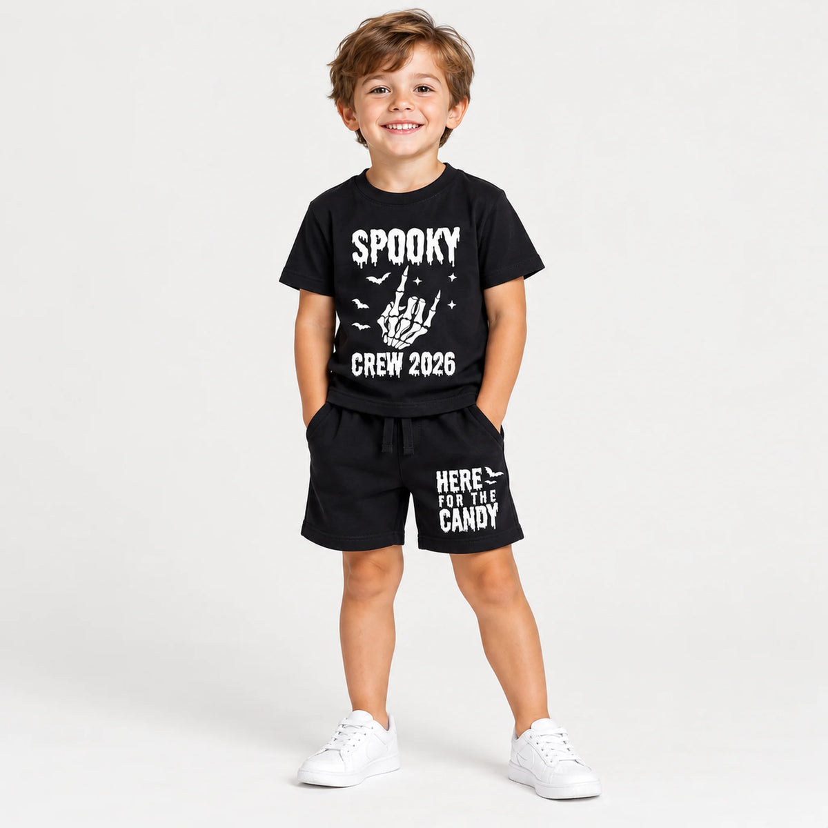 Boy wearing Spooky Crew 2026 Halloween shirt and matching shorts with skeleton hand and Here for the Candy designs