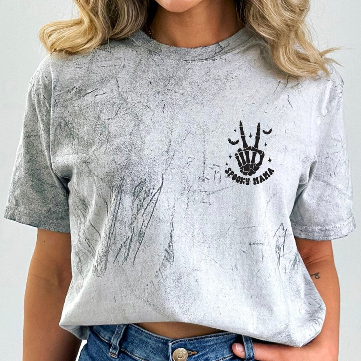Spooky Mama Halloween shirt featuring a black skeleton hand and bat graphic on the front of a garment-dyed t-shirt