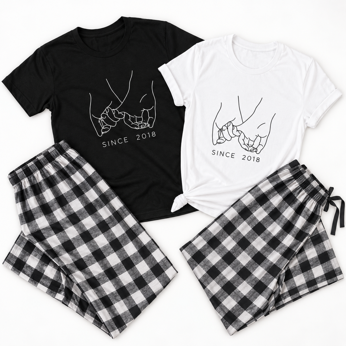 Personalized holding pinkies matching pajamas for couples featuring a black T-shirt and a white T-shirt with a custom established year design, paired with black and white buffalo plaid flannel pajama pants.