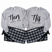 Matching His and Hers personalized gray sweatshirts with “Since 2026” prints and black-and-gray plaid pajama pants personalized with Anna & Eric.