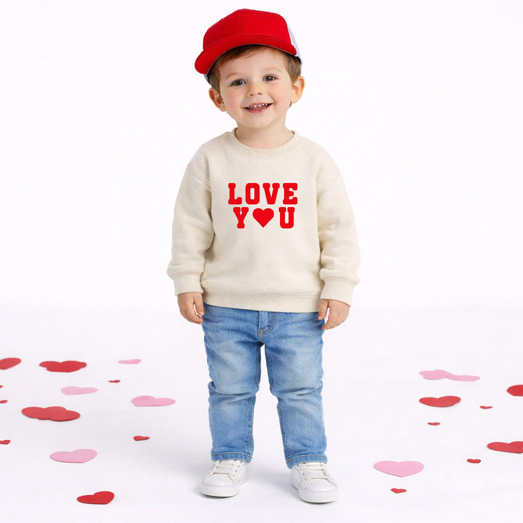 Toddler boy wearing natural color “Love You” sweatshirt on white background