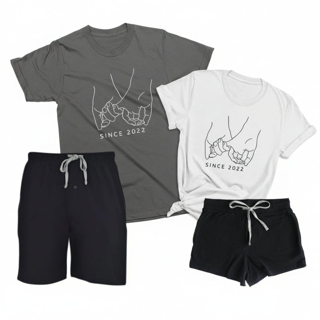 Couples pajama set with black men’s boxer shorts and asphalt-colored t-shirt paired with black women’s boxer shorts and white t-shirt, personalized with custom year