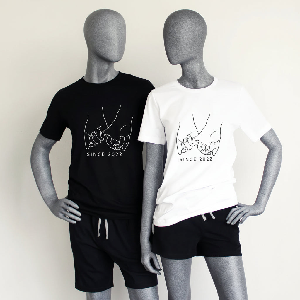 Matching personalized pajama set for couples displayed on mannequins with black boxer shorts, black men’s t-shirt, and white women’s t-shirt
