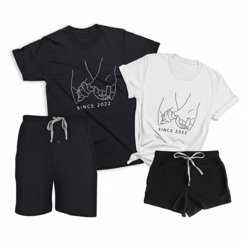 Personalized couples loungewear set with black boxer shorts, black men’s t-shirt, and white women’s t-shirt featuring pinky promise illustration and custom date